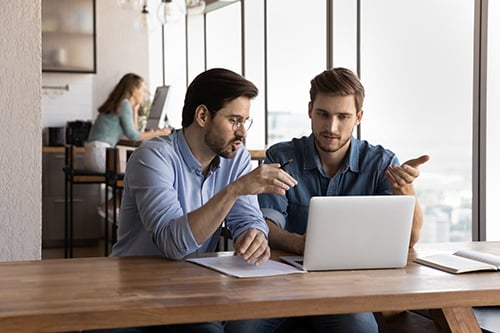 Two men working at a laptop