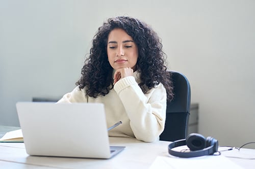 Woman sat at desk working on a laptop