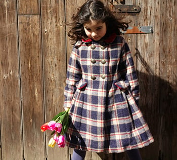 Girl in a tartan coat holding a bunch of flowers