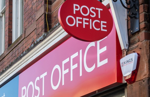 Post office sign hangs above storefront 