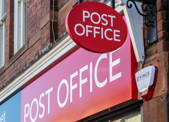 Post office sign hangs above storefront 