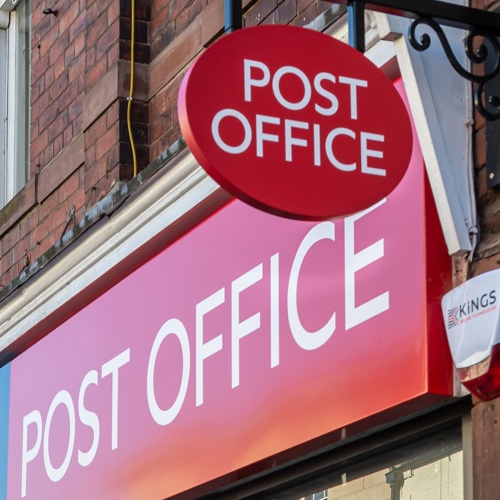 Post office sign hangs above storefront 