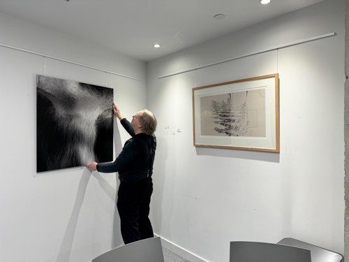 Artist Peter Hardie puts a picture on the wall